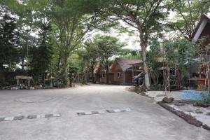 een lege straat voor een huis met bomen bij คันทรี รีสอร์ท  +1 foto