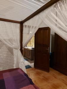 a bedroom with a bed with a mosquito net at Vacation home with pool in Ubud, Bali in Ubud