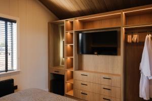 a bedroom with a entertainment center with a tv at Old Fargie Lodges in Perth