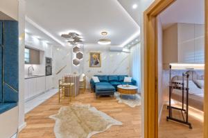 a living room with a blue couch and a kitchen at Queen Lidija in Zlatibor