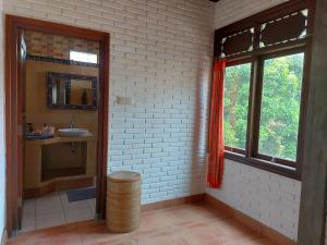 Un baño con lavabo, espejo y ventana. en Vacation home with pool in Ubud, Bali, en Ubud