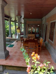 un patio con una mesa de madera y sillas en un porche en Vacation home with pool in Ubud, Bali, en Ubud