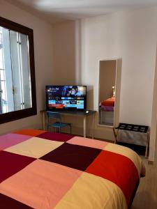a bedroom with a bed and a flat screen tv at Grey Heron's Nest, il tuo nido a Vicenza in Vicenza