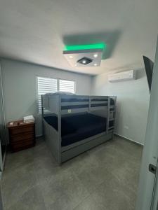 ein Schlafzimmer mit einem Etagenbett und grünem Licht in der Unterkunft Black Pearl in Guayama