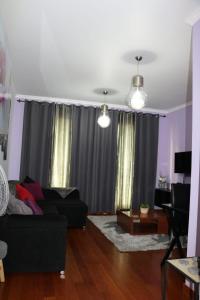 a living room with a black couch and curtains at Uptown Madalenas in Funchal