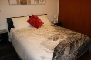a bed with two red pillows on top of it at Uptown Madalenas in Funchal