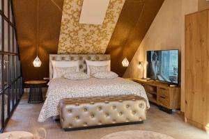 Hiša Ančka, Boutique Hotel & Maja Rooms في سلوفينج غرادتس: غرفة نوم بها سرير كبير وتلفزيون