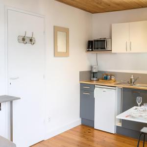 a kitchen with white cabinets and a microwave at Studio moderne, cosy & lumineux Chez Suzanne in Angers
