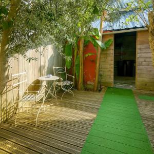 a patio with a table and chairs and a green rug at Studio moderne, cosy & lumineux Chez Suzanne in Angers