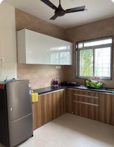 a kitchen with a refrigerator and a ceiling fan at Staymisty igatpuri in Igatpuri