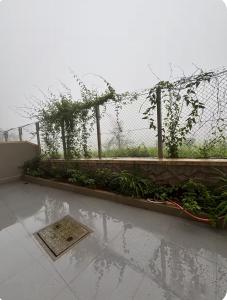a garden with a fence and some plants at Staymisty igatpuri in Igatpuri