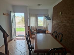 a dining room with a wooden table and chairs at Tranquilo duplex frente al mar in Monte Hermoso
