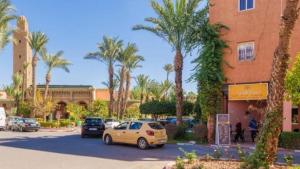 马拉喀什Riad Palm Oasis Marrakech的建筑物前停放汽车的停车场