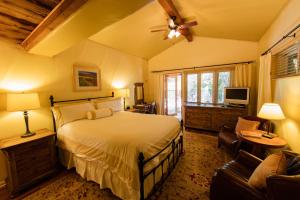 a bedroom with a bed and a tv and a couch at The Emerald Iguana Inn in Ojai