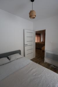 Un dormitorio con una cama blanca y un televisor. en MISI domek, en Kadłubówka