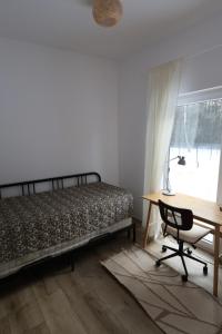 Un dormitorio con una cama y un escritorio y una ventana. en MISI domek, en Kadłubówka