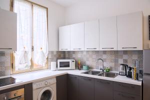 a kitchen with white cabinets and a washing machine at Dimora Castelli Free Parking in Marghera