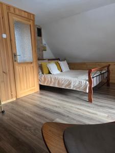 a bedroom with a bed and a wooden door at Nad Potokiem in Grąziowa
