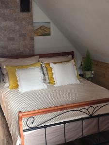 Nad Potokiem في Grąziowa: سرير مع وسائد صفراء وبيضاء في الغرفة