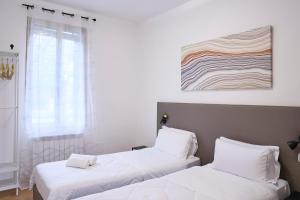 two beds in a room with white walls and a window at Dimora Castelli Free Parking in Marghera