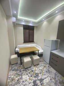 a small kitchen with a table and a refrigerator at Best Apartments in Khujand