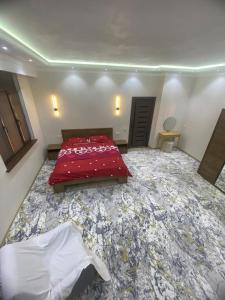 a large bedroom with a red bed and a floor covered in debris at Best Apartments in Khujand