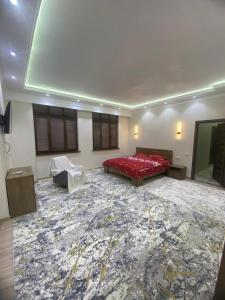a large room with a red bed and a carpet at Best Apartments in Khujand