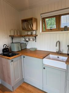 a kitchen with white cabinets and a sink at The Shepherds Rest in East Dean +34 photos