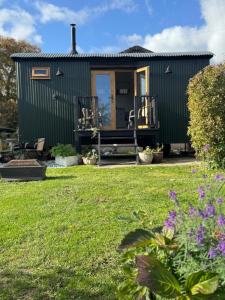 a green shipping container house with a yard at The Shepherds Rest in East Dean