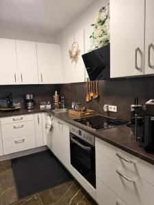 cocina con armarios blancos y fogones negros en Ferienwohnung-Weinstadt, en Weinstadt