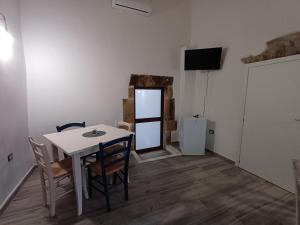 Pozzomaggioresa Domo Antiga的一间带桌椅和电视的餐厅