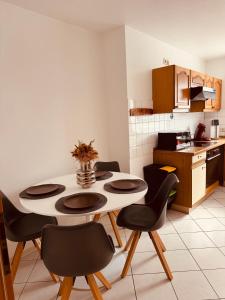 a kitchen with a table and chairs in a room at FeWo Haus 9 EUROPA PARK RULANTICA in Lahr +7 photos