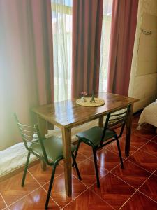 Una mesa de madera con dos sillas y un fregadero encima. en La Herradura, en Calingasta