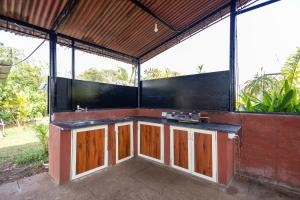 Nature Bloom Resort في Paror: مطبخ خارجي بخزائن خشبية في مبنى