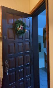 Una porta nera con una corona di fiori di Apzinho do Centro a Nova Petrópolis