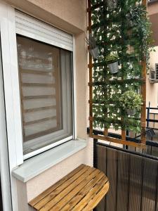 ein Fenster mit einer Holzbank neben einem Fenster in der Unterkunft Studio IKA Belgrade Airport Free Parking possible Self Check-In Terrace in Ledine