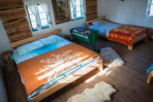 a bedroom with two beds in a log cabin at Vikend kuce i odmaraliste JuliE etno - Sarajevo Jahorina in Tvrdimići