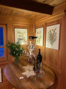 einen Tisch mit zwei Flaschen Wein und Blumen darauf in der Unterkunft Ca da Viola in Cavagnago + 36 Fotos