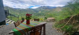 un tavolo con un vaso di fiori in cima a una montagna di Tampu Wasi a Vilcabamba