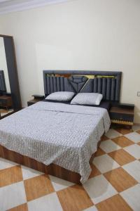 a bedroom with a bed and a checkered floor at najmatriff in Driouch +20 photos