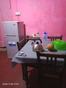 een tafel met een waterkoker op een tafel met een koelkast bij villa Harborend in Galle