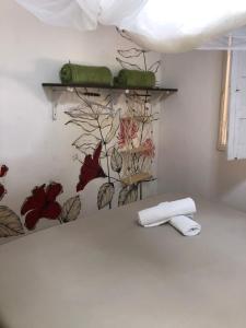 een kamer met een muur waarop bladeren geschilderd zijn bij Casa Gêmeos in Cayru