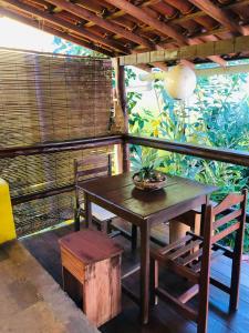 een houten tafel en stoelen op een balkon bij Casa Gêmeos in Cayru