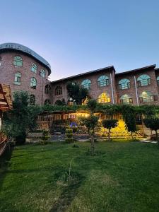 un gran edificio de ladrillo con un patio delante en Kabul Qargha Palace Hotel, Restaurant and wedding Hall, en Kabul