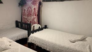 una camera con 2 letti singoli e una tenda di Un Café en el camino Guest House a Salento