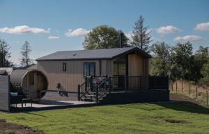 a small cabin with a porch and a fence at Old Fargie Lodges in Perth