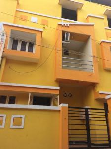 a yellow apartment building with a balcony and a staircase at DPD Beach Hotel in Puducherry