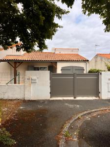 a house with a gate in front of it at Plain pied aux portes de La Rochelle 2chbres in Saint-Xandre