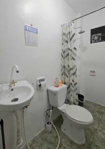 a bathroom with a white toilet and a sink at Duck and Drift Hostel - A sleeper Hostel in Puerto Princesa City