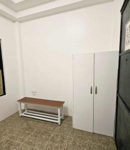 a room with a table and a bench in it at Duck and Drift Hostel - A sleeper Hostel in Puerto Princesa City